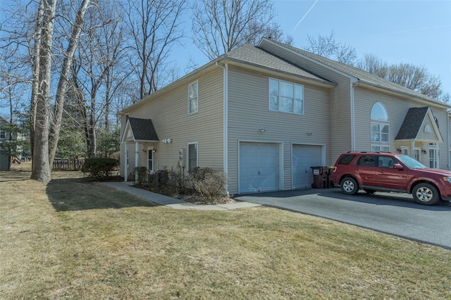 view of property exterior with aphalt driveway, a lawn, a garage, and a shingled roof