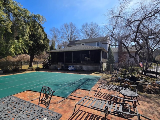 view of swimming pool with a patio area, fence, a fenced in pool, and a sunroom