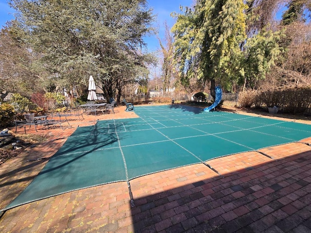 view of pool featuring a patio area, fence, and a water slide