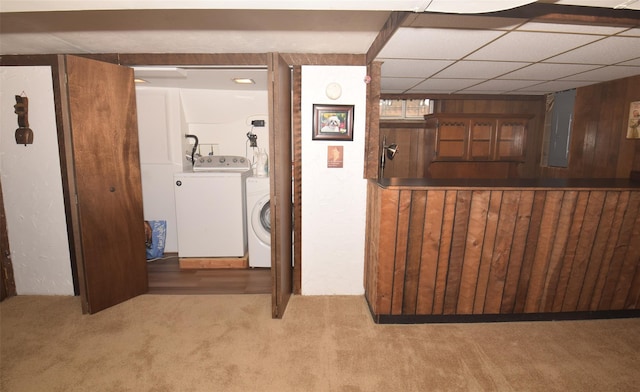 interior space featuring electric panel, laundry area, washing machine and clothes dryer, wood walls, and carpet flooring