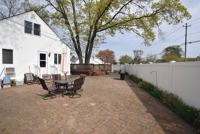 view of patio with a wooden deck, a fenced backyard, and entry steps
