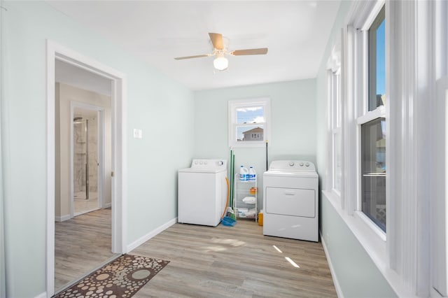 laundry area featuring wood finished floors, baseboards, laundry area, ceiling fan, and washing machine and dryer