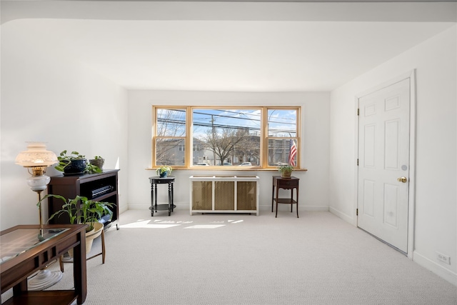 sitting room featuring radiator, baseboards, and carpet floors