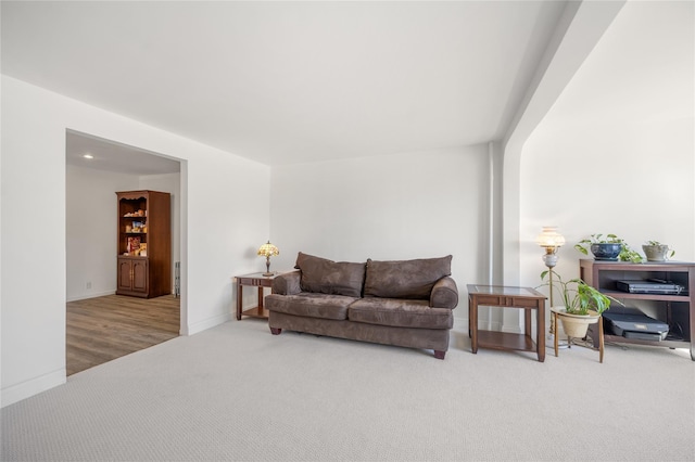 carpeted living area featuring baseboards