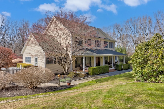 view of front of property with a front yard, a porch, and fence