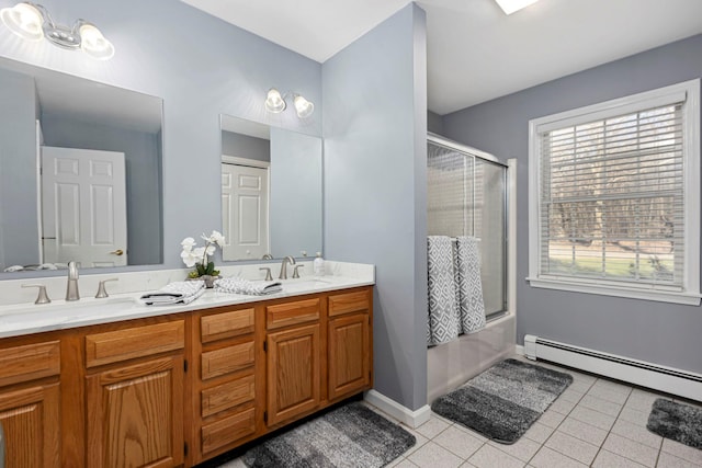 full bath featuring a baseboard heating unit, double vanity, tile patterned floors, enclosed tub / shower combo, and a sink