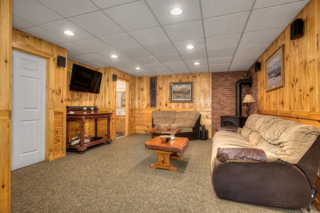 living area with recessed lighting, wood walls, a wood stove, and carpet