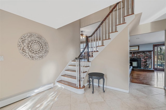 stairway with tile patterned floors, a fireplace, baseboards, and a baseboard radiator