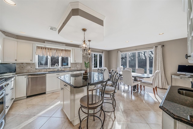 kitchen with dark stone counters, visible vents, backsplash, and stainless steel appliances