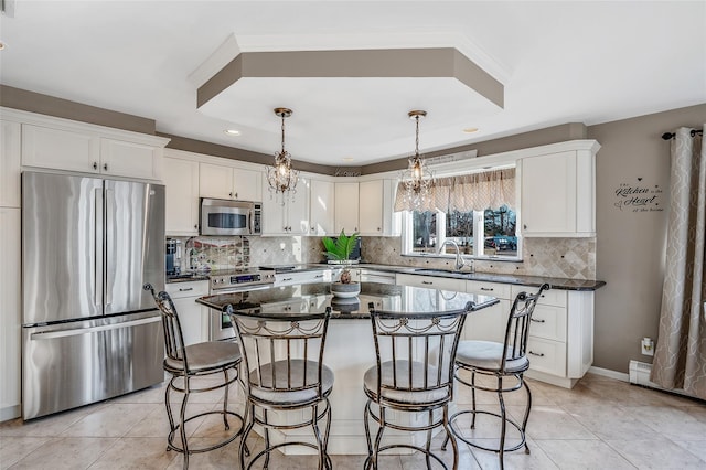 kitchen with white cabinets, a kitchen breakfast bar, stainless steel appliances, and a sink