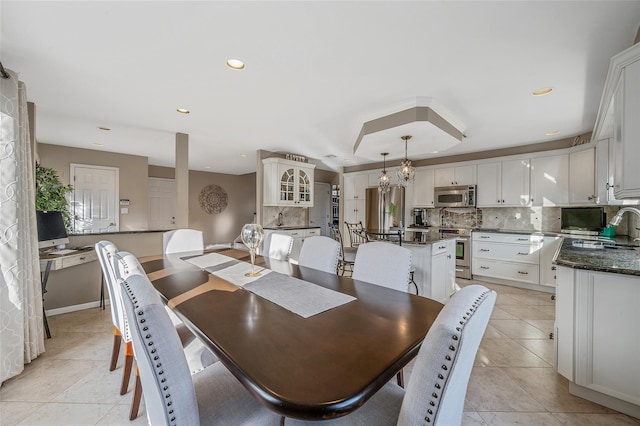 dining space with recessed lighting, baseboards, an inviting chandelier, and light tile patterned floors