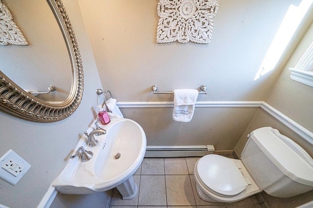 bathroom with tile patterned flooring, toilet, and a baseboard radiator