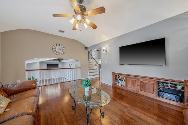 living room featuring visible vents, vaulted ceiling, hardwood / wood-style flooring, arched walkways, and a ceiling fan