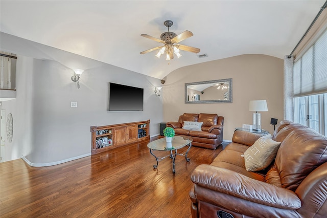 living area with wood finished floors, baseboards, visible vents, ceiling fan, and vaulted ceiling