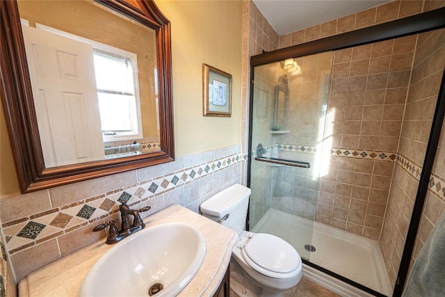 bathroom featuring vanity, tile walls, toilet, and a stall shower