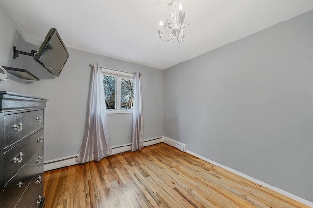 unfurnished bedroom with a chandelier, light wood finished floors, a baseboard heating unit, and baseboards