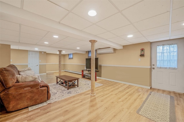 living room featuring baseboards, wood finished floors, a baseboard radiator, and a wall mounted AC