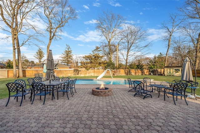 view of patio / terrace with a fire pit, a fenced in pool, and a fenced backyard