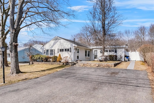 view of front of house featuring a gate, fence, and driveway
