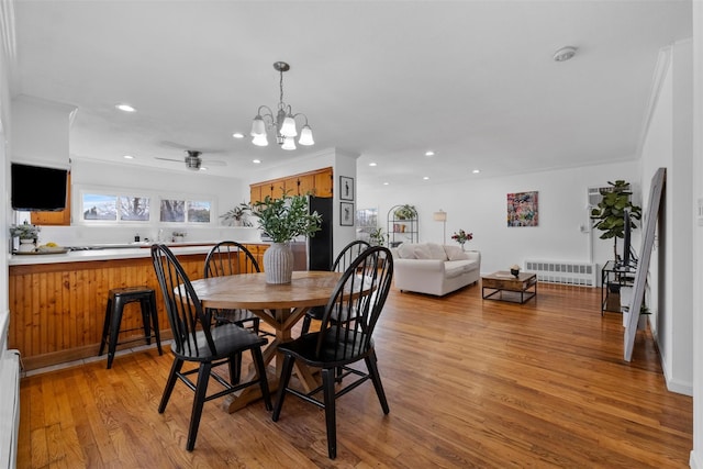 dining space with recessed lighting, radiator, ceiling fan with notable chandelier, and light wood-type flooring