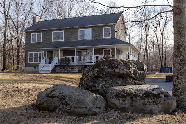 colonial-style house with covered porch and a chimney