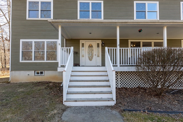 view of exterior entry featuring crawl space and covered porch