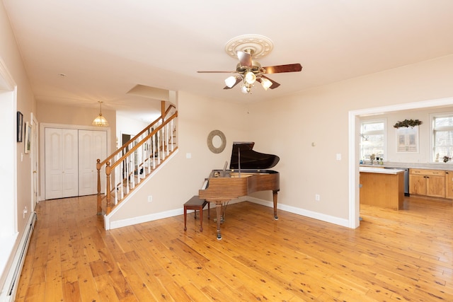 office area featuring ceiling fan, baseboards, baseboard heating, and light wood-style flooring