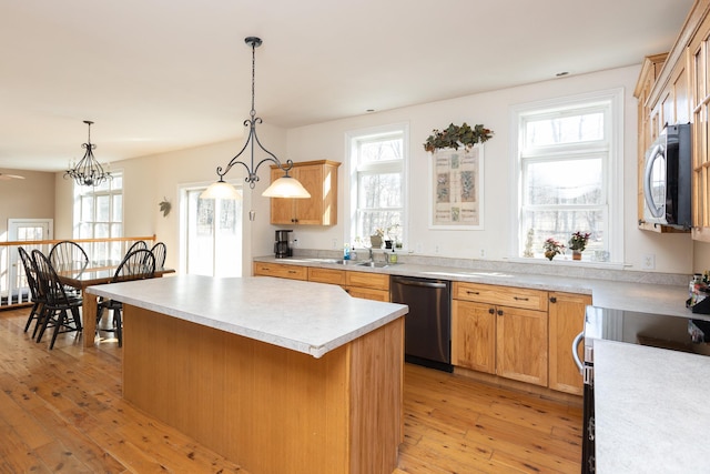 kitchen with light wood-type flooring, range with electric cooktop, stainless steel dishwasher, a kitchen island, and light countertops