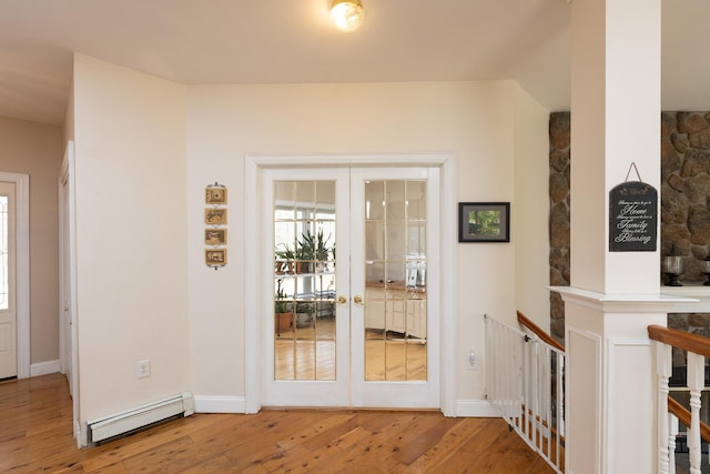 interior space with an upstairs landing, hardwood / wood-style flooring, a baseboard heating unit, french doors, and baseboards