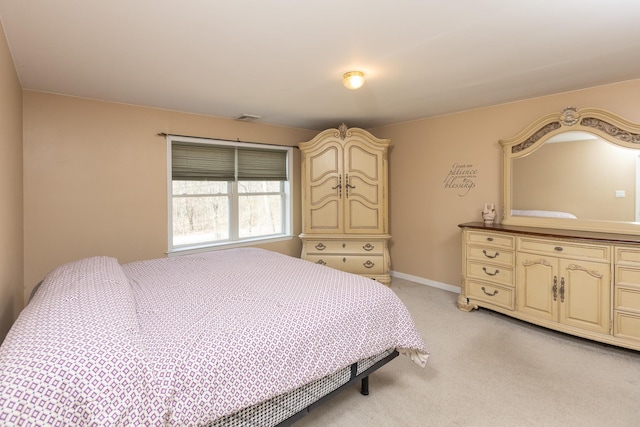 bedroom with baseboards, visible vents, and light carpet