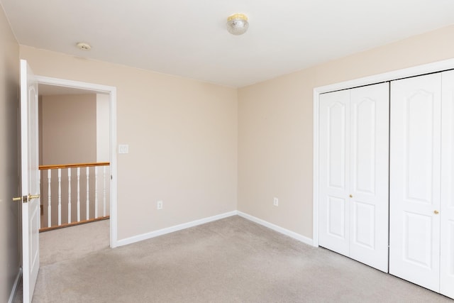 unfurnished bedroom featuring a closet, baseboards, and carpet