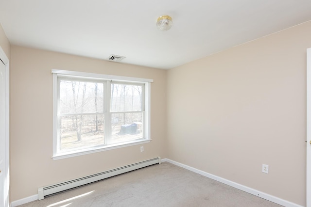 spare room with a baseboard heating unit, baseboards, light colored carpet, and visible vents