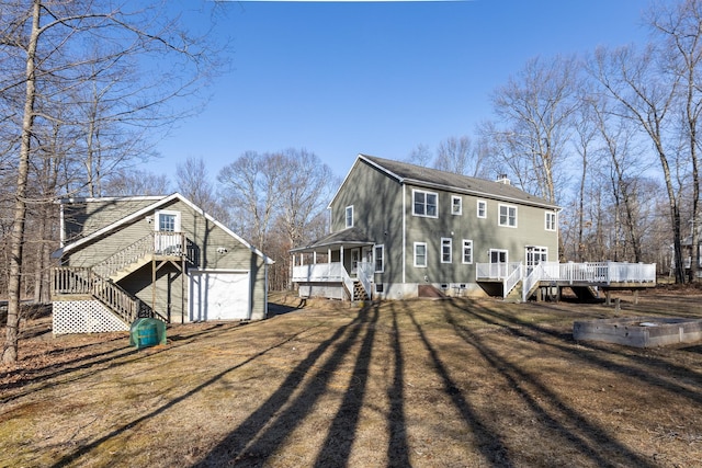 rear view of house with a deck, a chimney, and a yard