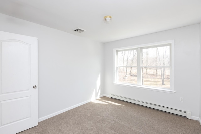 carpeted empty room featuring baseboards, visible vents, and baseboard heating