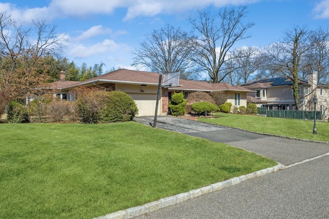 ranch-style house with stucco siding, driveway, a front lawn, and a garage