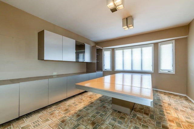 kitchen featuring brick patterned floor and baseboards