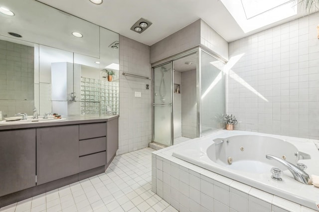 full bath featuring tile patterned flooring, tile walls, a skylight, and a tile shower