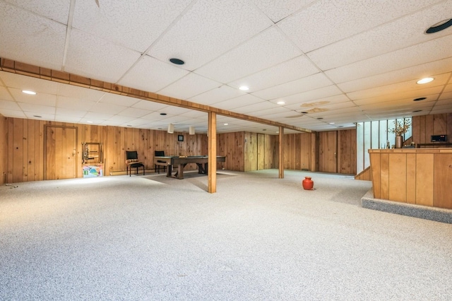 finished basement with carpet flooring, wood walls, billiards, and bar