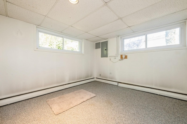 basement with electric panel and a paneled ceiling