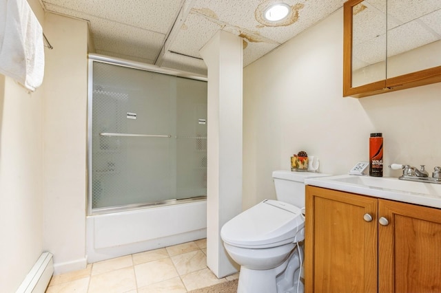 bathroom featuring tile patterned floors, a baseboard heating unit, toilet, enclosed tub / shower combo, and vanity