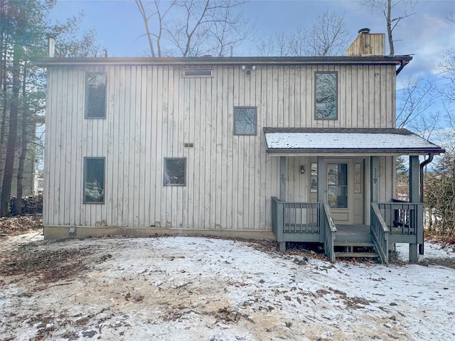 view of front facade with covered porch and a chimney