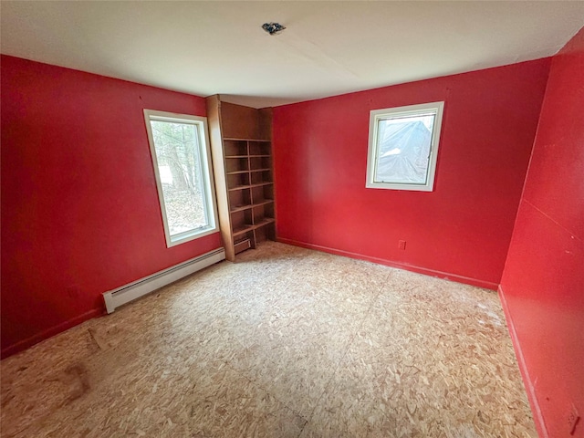 carpeted spare room featuring baseboards and a baseboard radiator