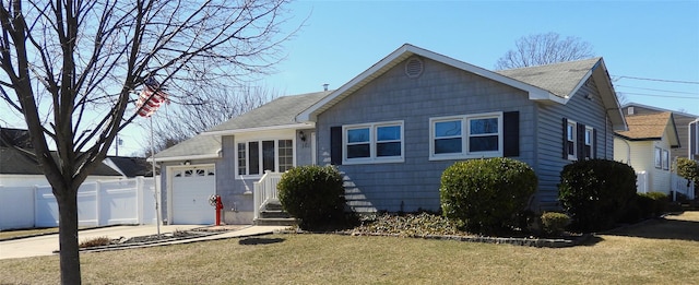 view of front facade featuring fence, roof with shingles, an attached garage, a front lawn, and concrete driveway