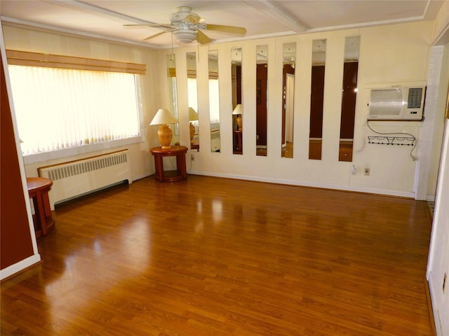 unfurnished room featuring radiator, a ceiling fan, a wall unit AC, and wood finished floors