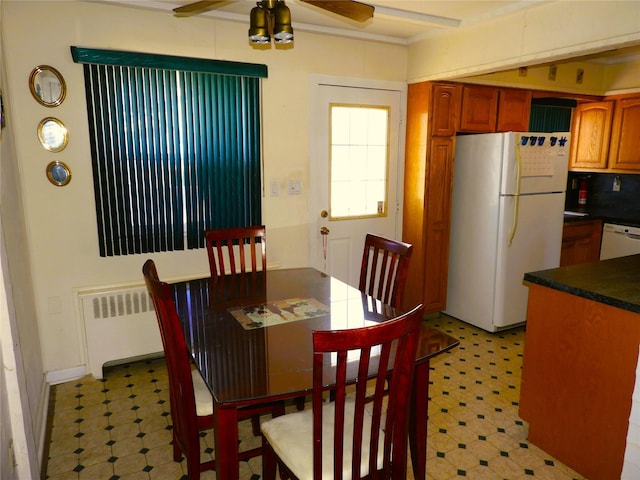 dining room with light floors, radiator heating unit, and a ceiling fan