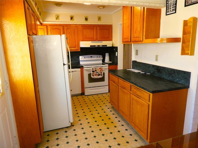 kitchen featuring white appliances, exhaust hood, dark countertops, and light floors