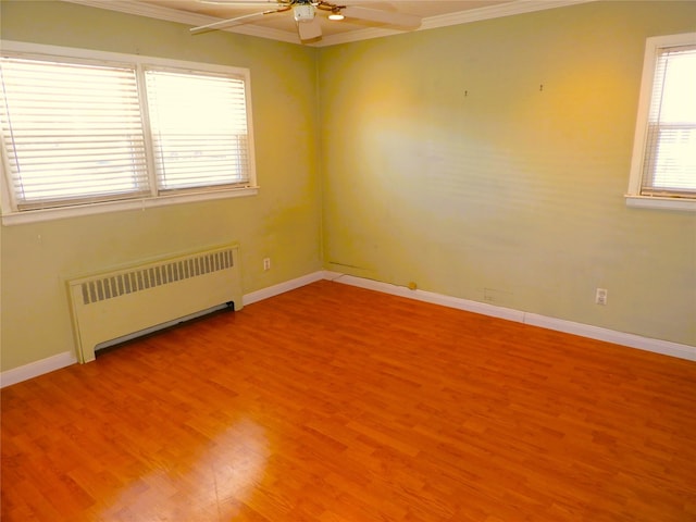 unfurnished room featuring radiator, baseboards, ornamental molding, light wood-style flooring, and a ceiling fan