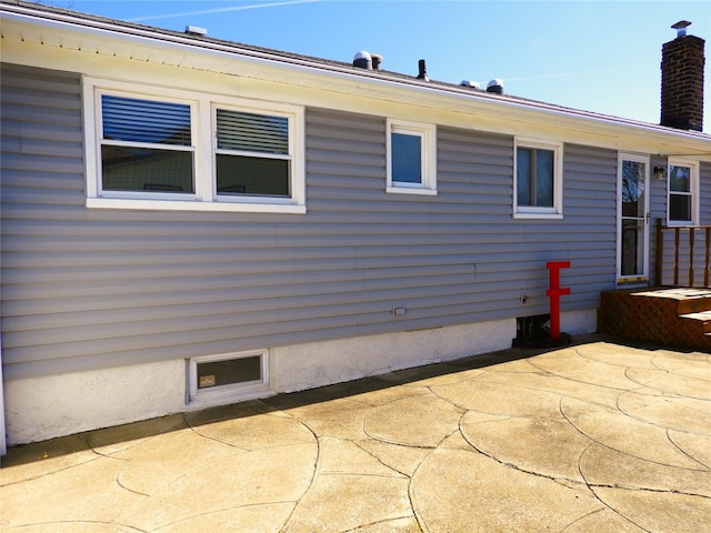 view of side of property with a patio and a chimney