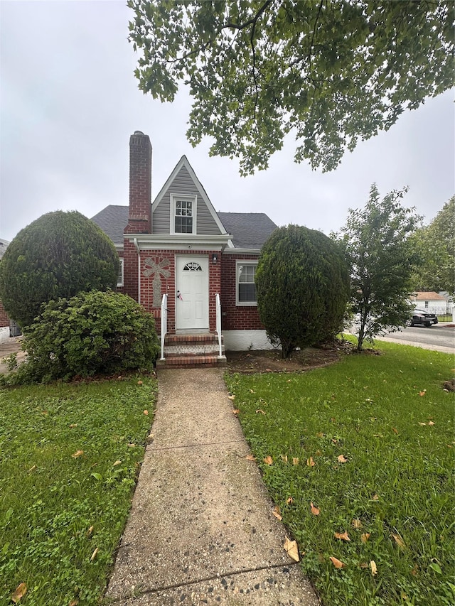 223-45 113th Dr, Queens Village, NY 11429 - view of front of property with brick siding, a front lawn, and a chimney