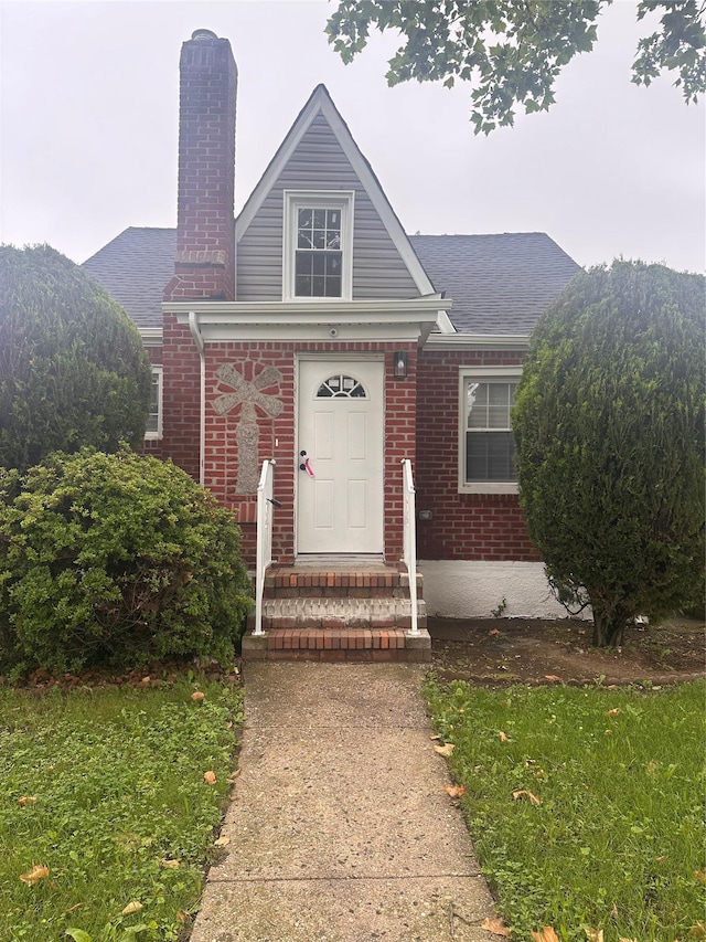 223-45 113th Dr, Queens Village, NY 11429 - view of front of house featuring a chimney, brick siding, and roof with shingles